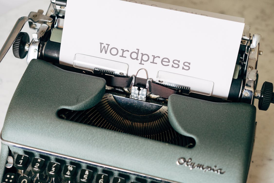 a picture of a typewriter with the words Wordpress printed on a piece of paper inside the typewriter